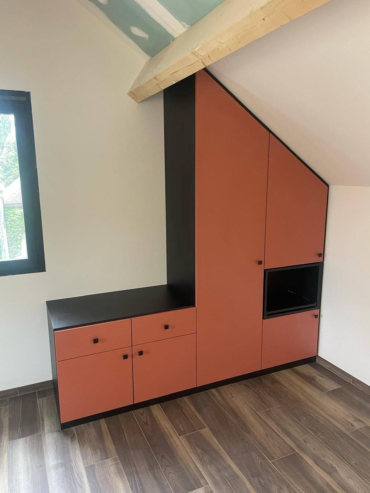 Meuble sous pente terracotta avec niche et plan noir, sous poutre apparente, à Marne-la-Vallée
